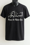 Black Assalamu Alaikum Arabic calligraphy T-shirt featuring السلام عليكم and Peace Be Upon You text in white print, modest Islamic streetwear tee for women, Muslim graphic shirt USA