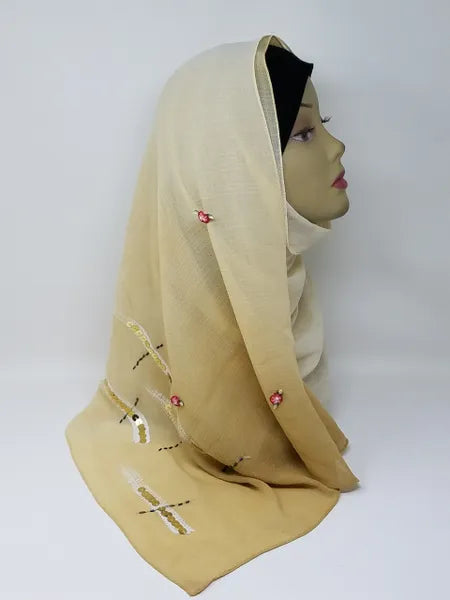 Beige chiffon hijab scarf with small decorative accents displayed on mannequin, soft lightweight breathable fabric, elegant modest headscarf for women, smooth drape hijab for everyday and occasion wear