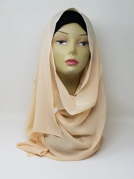 Beige chiffon hijab scarf displayed on mannequin, soft neutral flowy fabric, lightweight breathable modest headscarf for women, elegant drape chiffon hijab for everyday wear and special occasions, smooth nude tone scarf from Affordable Hijab USA