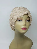 Beige embellished turban headwrap with pearl and bead details on mannequin, elegant modest headwear with textured design, soft structured fit for special occasions, front and side view showing decorative finish