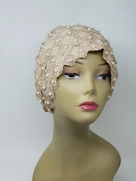 Beige embellished turban headwrap with pearl and bead details on mannequin, elegant modest headwear with textured design, soft structured fit for special occasions, front and side view showing decorative finish