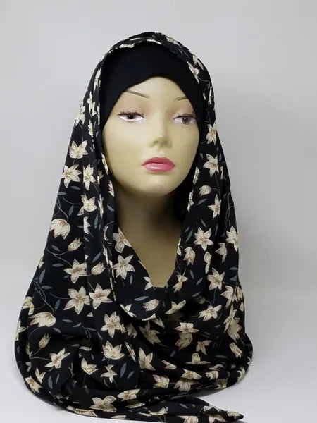 Black floral print hijab scarf for Muslim women displayed on mannequin, lightweight modest headscarf with floral pattern for everyday wear prayer and modest fashion styling