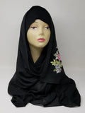 Black hijab scarf with colorful floral print on the side displayed on mannequin, modest Muslim headscarf for women, elegant black hijab wrap for everyday modest fashion and Islamic clothing.