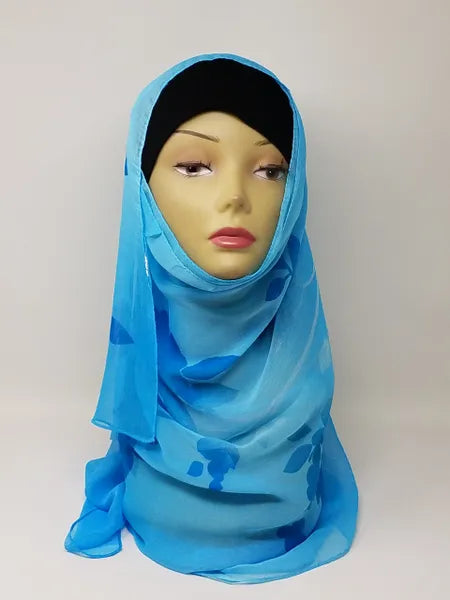 Blue hijab scarf worn on mannequin, lightweight modest headscarf for women, soft flowy fabric drape, full coverage hijab style, simple elegant wrap for everyday wear, breathable and comfortable scarf, bright blue modest fashion accessory, easy to style hijab for casual and formal outfits, front and side view