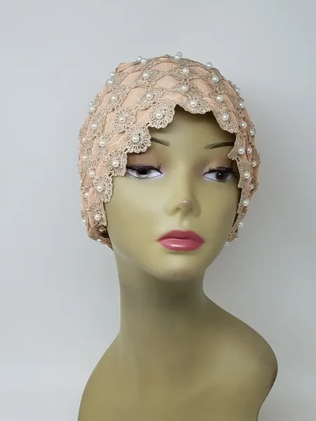 Blush pink embellished turban headwrap with pearl and bead details on mannequin, elegant modest headwear with textured design, soft structured fit for special occasions, front and side view showing decorative finish