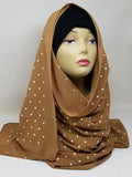 Brown chiffon hijab scarf with gold polka dot pattern displayed on mannequin, lightweight modest fashion headscarf with soft drape perfect for everyday wear, casual outfits, and stylish hijab styling.