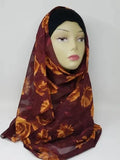 Burgundy floral georgette hijab draped on mannequin, lightweight breathable scarf with gold leaf pattern, soft textured matte fabric, flowy elegant modest head covering for women, stylish hijab for everyday wear and special occasions