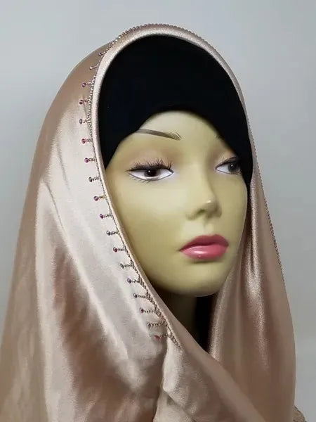 Champagne satin hijab scarf with lace trim and rhinestone detailing along the edge, elegant modest fashion headscarf with smooth satin fabric drape designed for everyday wear, weddings, formal events, and stylish hijab outfits.