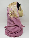 Elegant dusty pink hijab with gold beaded embroidery and rhinestone embellishments draped on mannequin head, luxury modest fashion scarf perfect for weddings, Eid celebrations, and formal Islamic events.