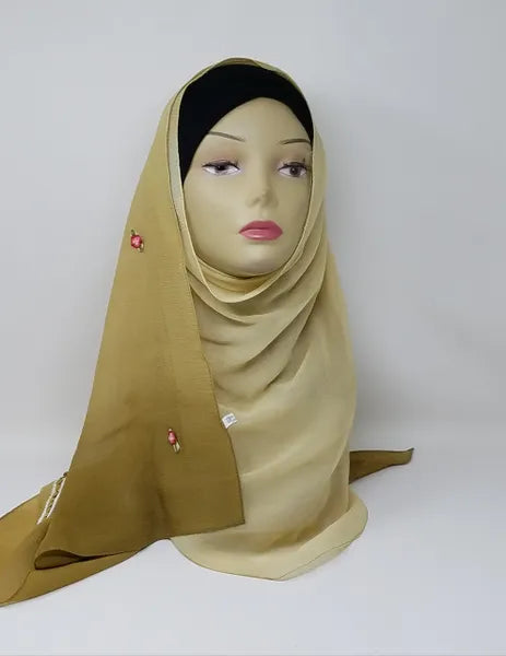 Gold chiffon hijab scarf displayed on mannequin, lightweight soft fabric with smooth drape, modest fashion hijab for women, elegant breathable scarf for everyday wear and special occasions