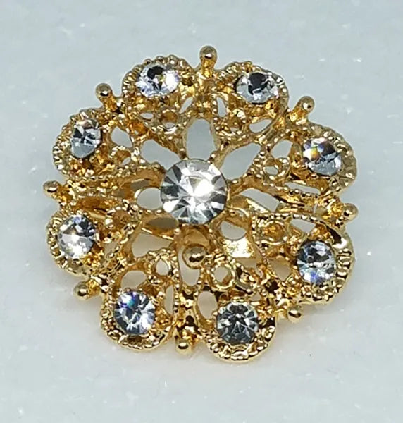 Gold rhinestone flower brooch pin for hijab styling, elegant crystal hijab pin brooch accessory for scarves, abayas, and modest fashion outfits, decorative gold floral pin for securing hijabs and shawls, luxury modest fashion accessory for women, sparkling crystal brooch for hijab, scarf brooch jewelry for elegant modest wear.