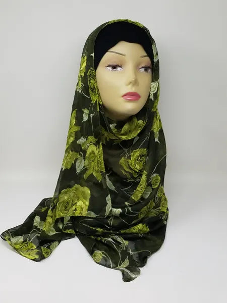 Green floral georgette hijab draped on mannequin, lightweight breathable scarf with leafy pattern, soft textured matte fabric, flowy elegant modest head covering for women, stylish hijab for everyday wear and special occasions