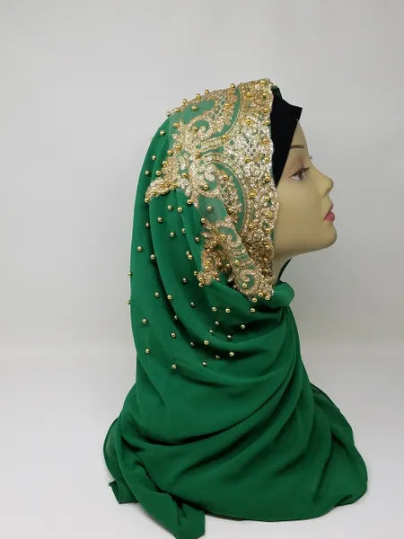 Elegant green hijab with gold beaded embroidery and rhinestone embellishments draped on mannequin head, luxury modest fashion scarf for weddings, Eid celebrations, and formal Islamic wear.