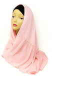 Light pink chiffon hijab scarf made from soft lightweight fabric, elegant modest Muslim headscarf draped on mannequin for breathable everyday hijab styling.
