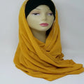 Mustard yellow chiffon hijab scarf draped on mannequin, lightweight modest headscarf, soft flowy fabric, elegant everyday wear for Muslim women, full coverage styling, breathable chiffon material, long wrap hijab for casual and formal outfits