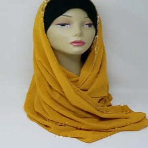 Mustard yellow chiffon hijab scarf draped on mannequin, lightweight modest headscarf, soft flowy fabric, elegant everyday wear for Muslim women, full coverage styling, breathable chiffon material, long wrap hijab for casual and formal outfits