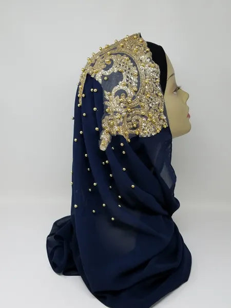 Elegant navy blue hijab with gold beaded embroidery and rhinestone embellishments draped on a mannequin head, luxury modest fashion scarf for special occasions, weddings, Eid, and formal Islamic wear.