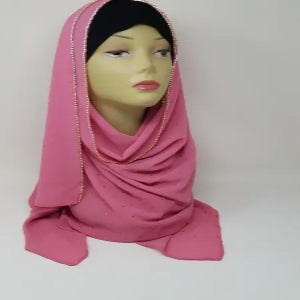 Pink chiffon hijab scarf draped on mannequin, soft lightweight modest headscarf, breathable flowy fabric, elegant full coverage hijab for women, simple solid color scarf for everyday and formal wear, long wrap hijab styling