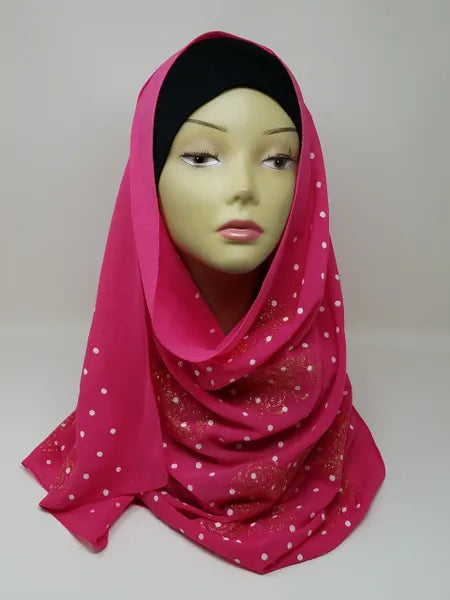Pink chiffon hijab scarf with gold polka dot pattern displayed on mannequin head, lightweight modest fashion headscarf perfect for everyday wear and elegant hijab styling.