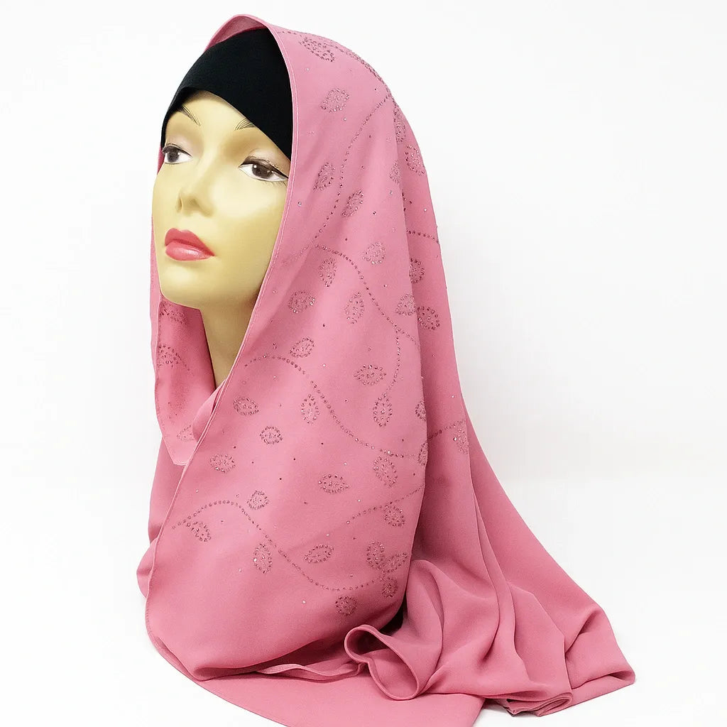 Soft pink chiffon hijab with rhinestone embellishments displayed on mannequin, elegant modest fashion headscarf for Muslim women, lightweight breathable chiffon scarf perfect for Eid, weddings, and everyday wear.