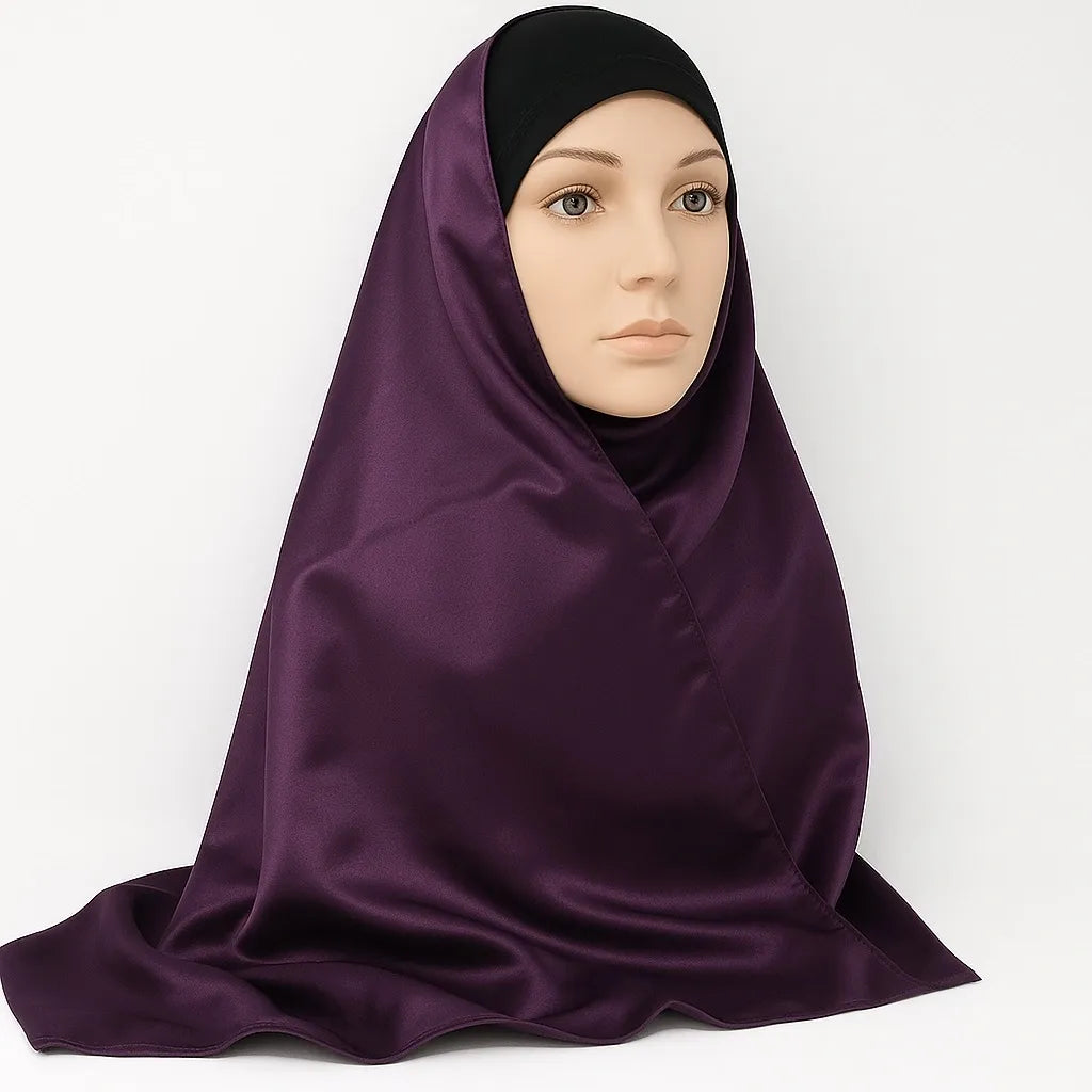 Deep plum silky finish hijab scarf draped on model, dark purple smooth satin look modest head scarf lightweight elegant wrap for daily and formal wear.