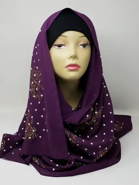 Purple chiffon hijab scarf with gold polka dot pattern displayed on mannequin head, lightweight modest fashion headscarf with soft drape perfect for everyday wear, casual outfits, and elegant hijab styling.