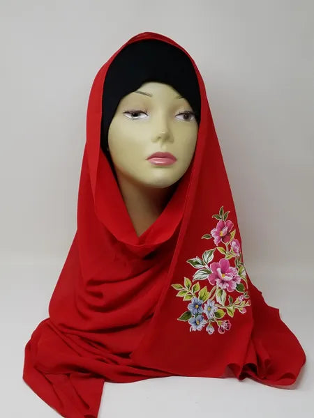 Red hijab scarf with colorful floral print on the side displayed on mannequin, modest Muslim headscarf for women, elegant red hijab wrap for everyday modest fashion and Islamic clothing