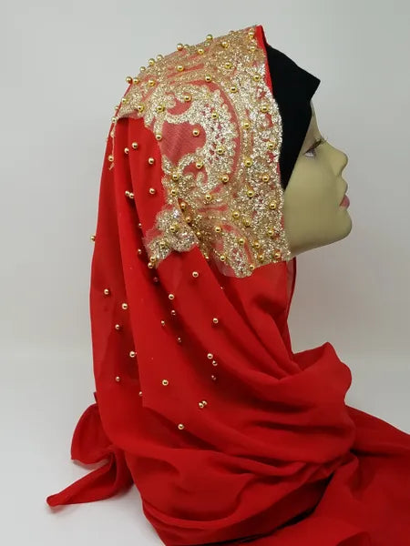 Elegant red hijab with gold beaded embroidery and rhinestone embellishments draped on mannequin head, luxury modest fashion scarf for weddings, Eid celebrations, and formal Islamic occasions.