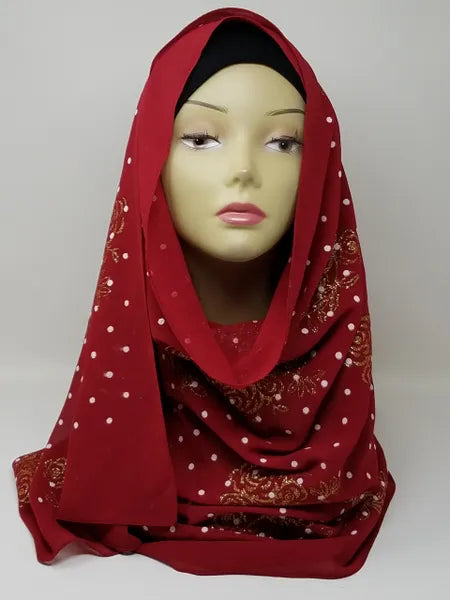 Red chiffon hijab scarf with gold polka dot pattern displayed on mannequin head, lightweight modest fashion headscarf with soft drape perfect for everyday wear and elegant hijab styling.