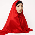 Red silky finish hijab scarf draped on model, lightweight smooth modest head scarf with satin look shine for elegant daily wear and special occasions.