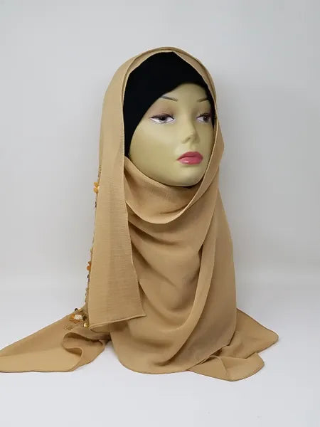 Tan chiffon hijab scarf displayed on mannequin, warm neutral flowy fabric, lightweight breathable modest headscarf for women, elegant drape chiffon hijab for everyday wear and styling, soft smooth scarf from Affordable Hijab USA